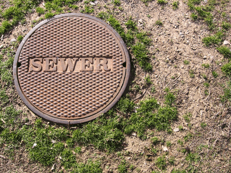 Metal sewer lid in a yard - Boyd Plumbing